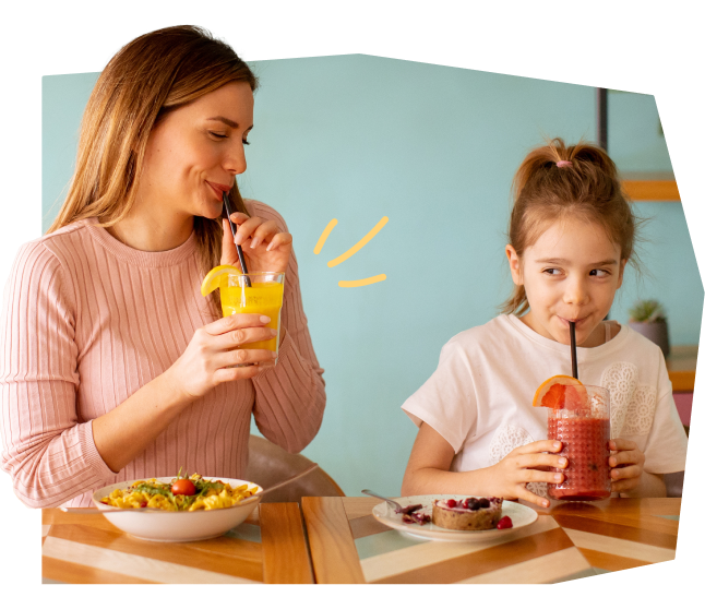 Two girls drinking fruit juice